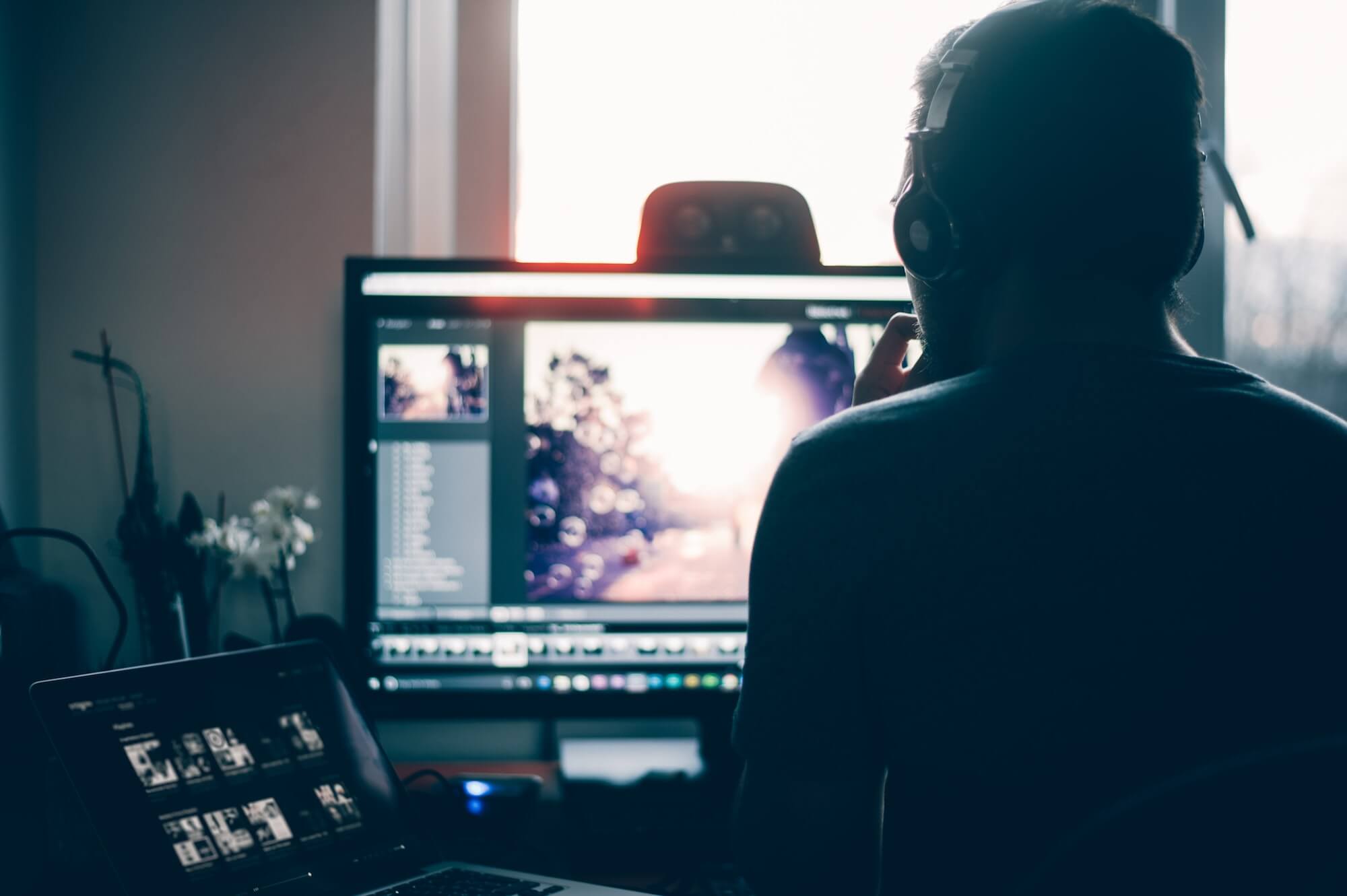  A person engaged in manual photo editing using advanced software, with a focus on a computer screen displaying image adjustment tools for sharpness, brightness, and color enhancements.