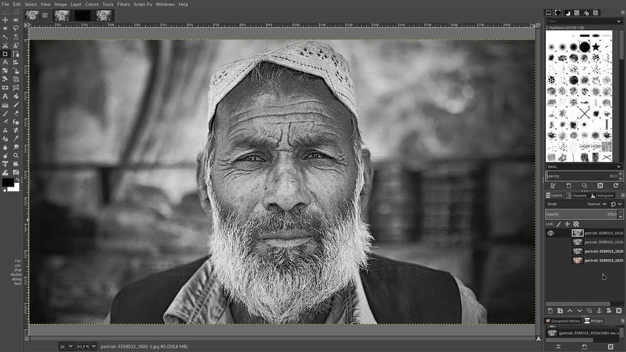 A grayscale image of an elderly man with a beard open in GIMP photo editing software, demonstrating the process of enhancing a normal photo to HD quality as part of an instructional guide.